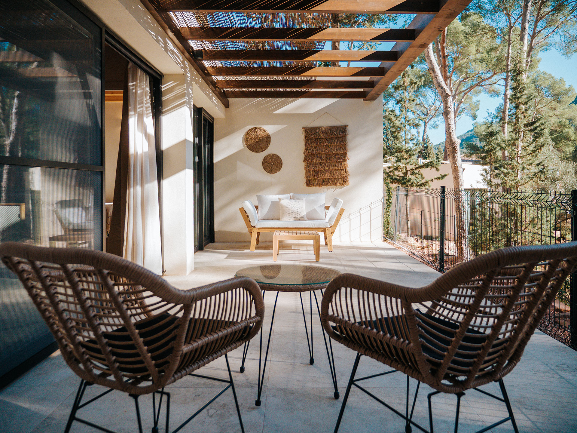 Terraza exterior con sofá de madera y sillas para 2 personas