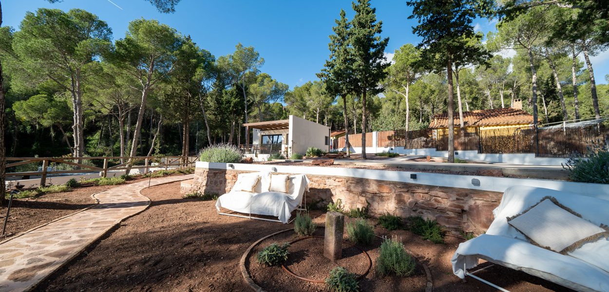 Espacio al aire libre al lado del acceso a una de las cabañas con sofás en el exterior